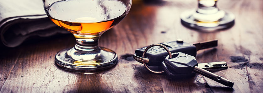 set of keys laying beside alcoholic beverage