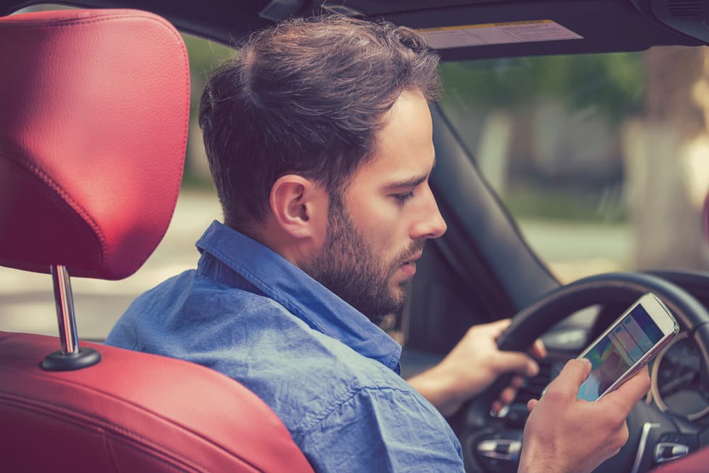 distracted driver texting on his phone