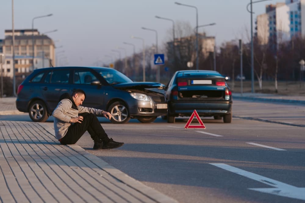 man waiting for paramedics after car accident