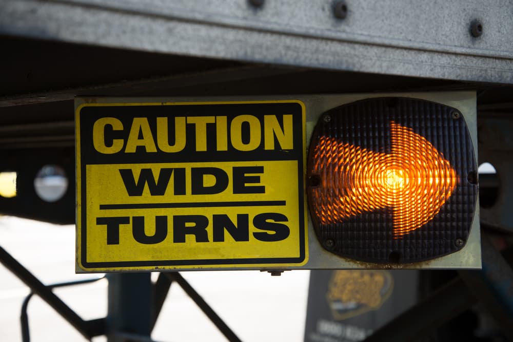 caution truck wide turns sign