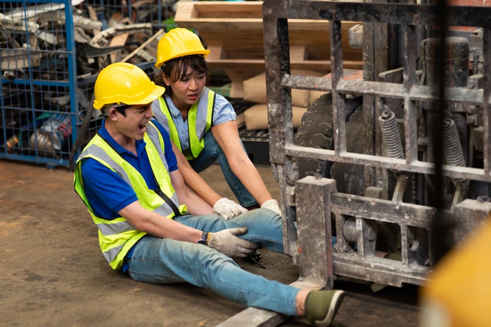 worker with foot caught in heavy equipment at work