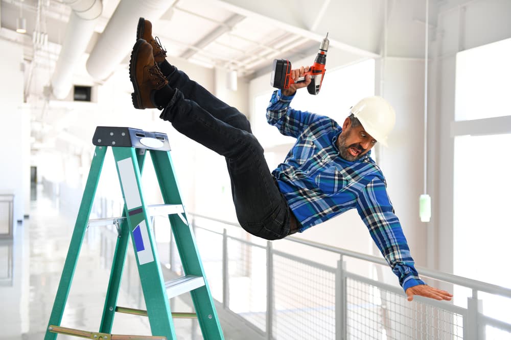 construction worker falling off ladder onto back