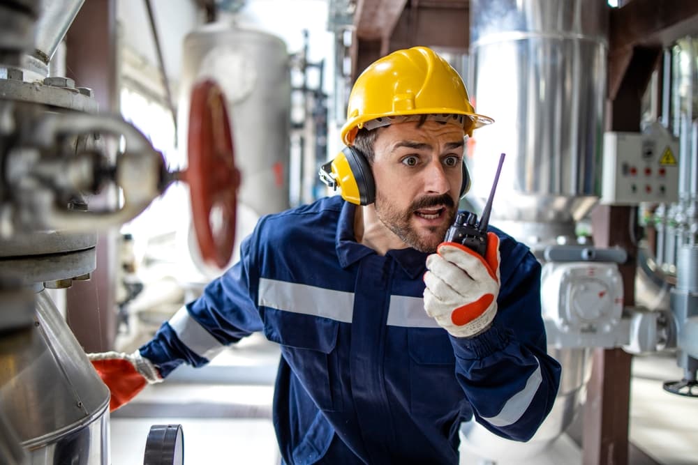 Factory worker in panic alerting about an explosion in refinery