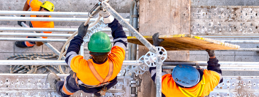 two construction workers looking over a scaffold